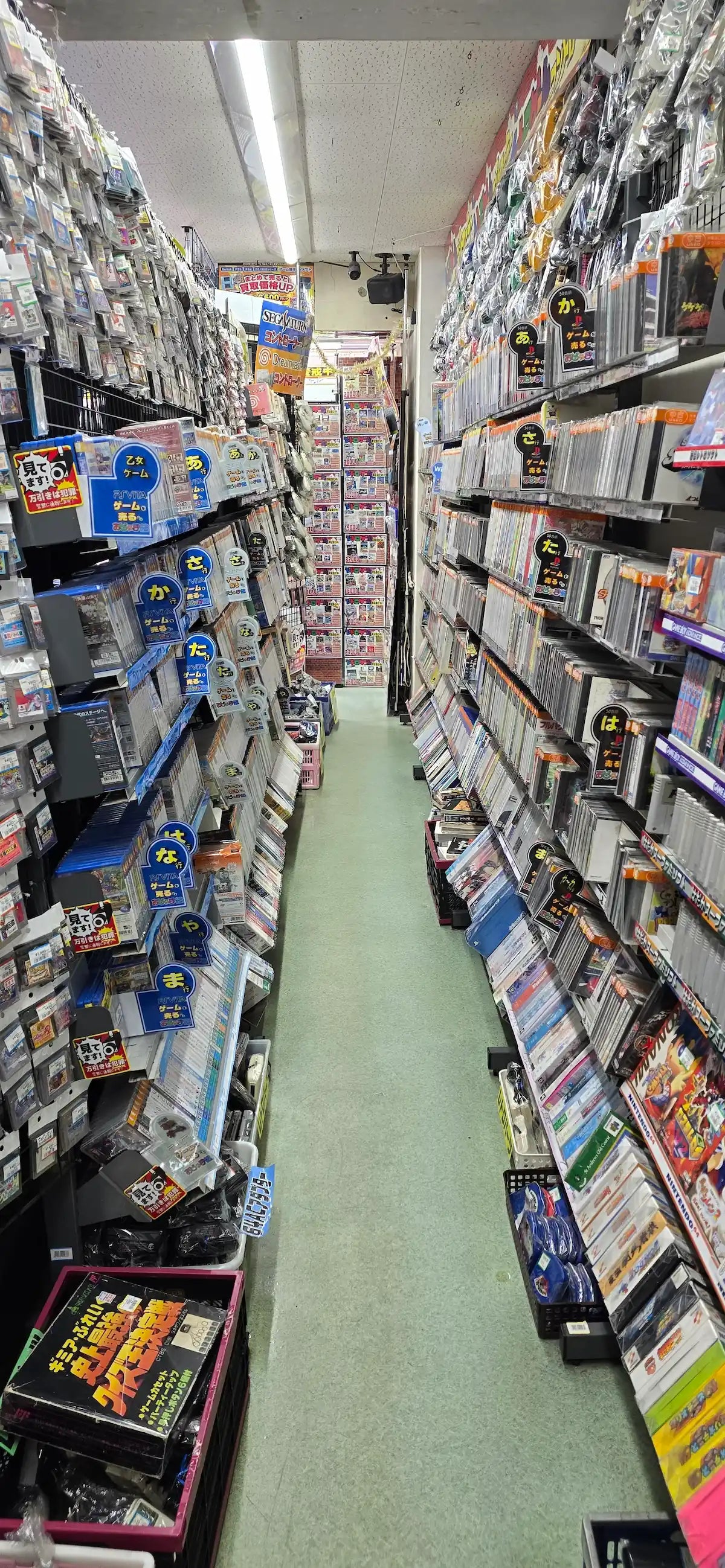 Japanese retro gaming store aisle packed with consoles and games, symbolizing RetroPixl’s Find It For Me service to track rare collectibles.