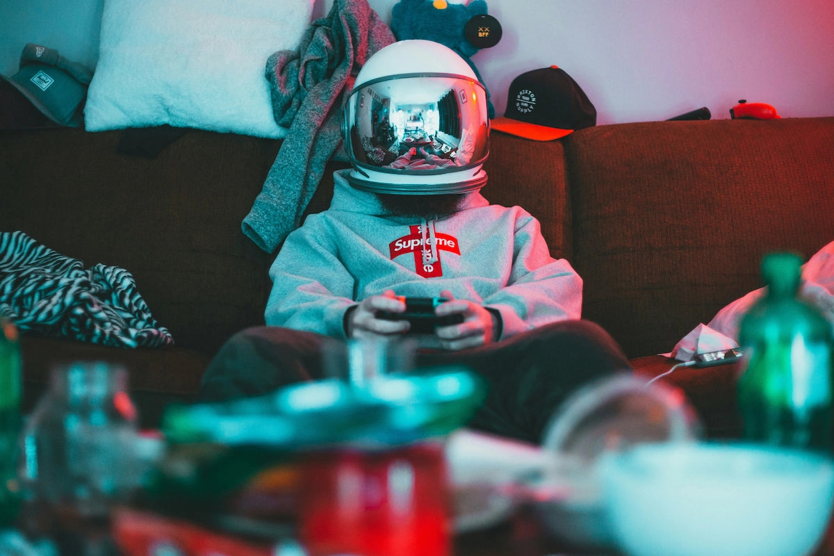 Gamer in astronaut helmet playing at home, symbolizing RetroPixl’s playful retro gaming community.